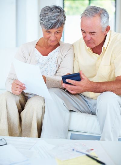 Domestic budgeting. Happy mature couple calculating...