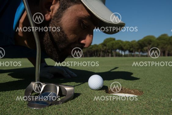 golf player blowing ball in hole