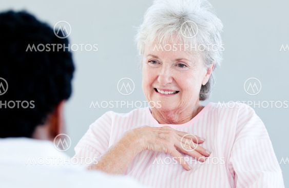 Smiling senior patient sitting on a wheelchair talking with her doctor