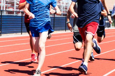 High school boys traiining together on a red track
