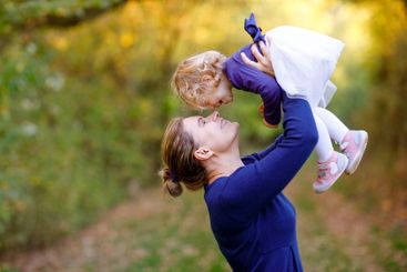 Happy young mother having fun cute toddler daughter,...