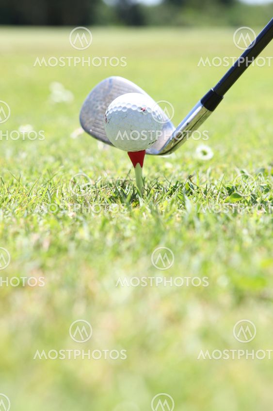 Närbild på en golfboll, club och tee