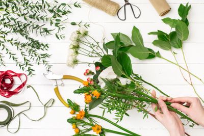 Female florist making beautiful bouquet at flower shop