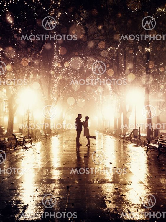 Couple walking at alley in night lights. Photo in vintage style.