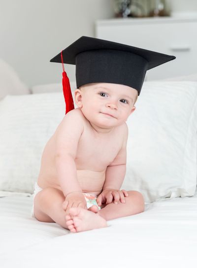10 months old baby boy in black graduation cap with tassel