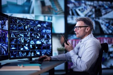 Male Security Guard Talking On Walkie-talkie