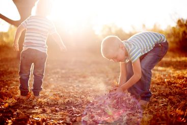 Leaves, game and boys in playground, fun and bonding...