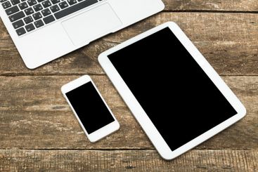 Modern workspace with laptop, tablet, and smartphone on...