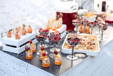 Elegant catering setup with glasses of figs and berries...