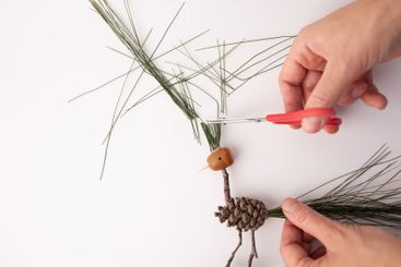 A handmade bird crafted from pine cones and twigs, a...