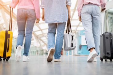 Traveling companions walking with luggage in modern...