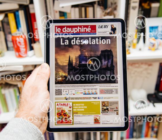 Man reading on iPad Pro about Notre-Dame de Paris fire