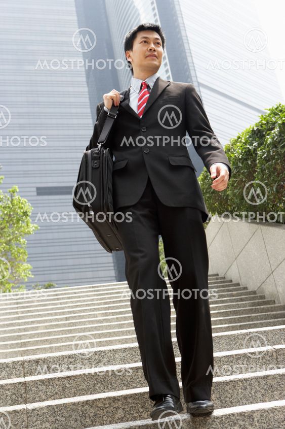 Chinese Businessman Walking Down Steps Carrying Bag Outside Office