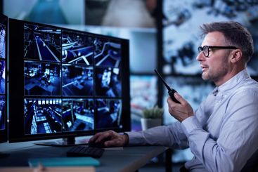 Male Security Guard Talking On Walkie-talkie