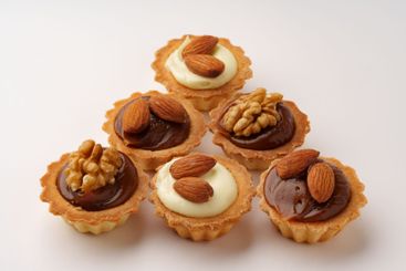 Delicious nut-topped pastry cups arranged in a...