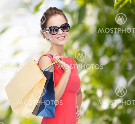 smiling elegant woman in dress with shopping bags