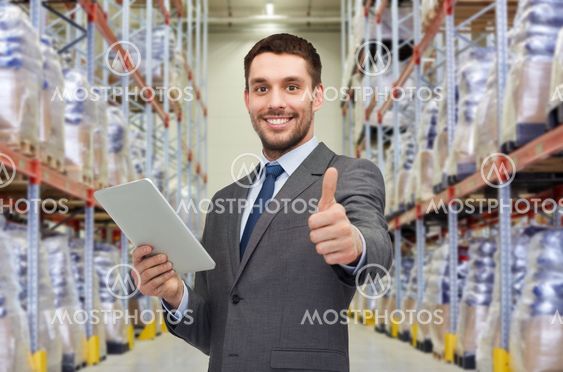 businessman with tablet pc over warehouse