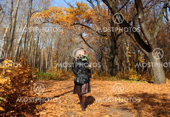 girl walking in autumn park alley