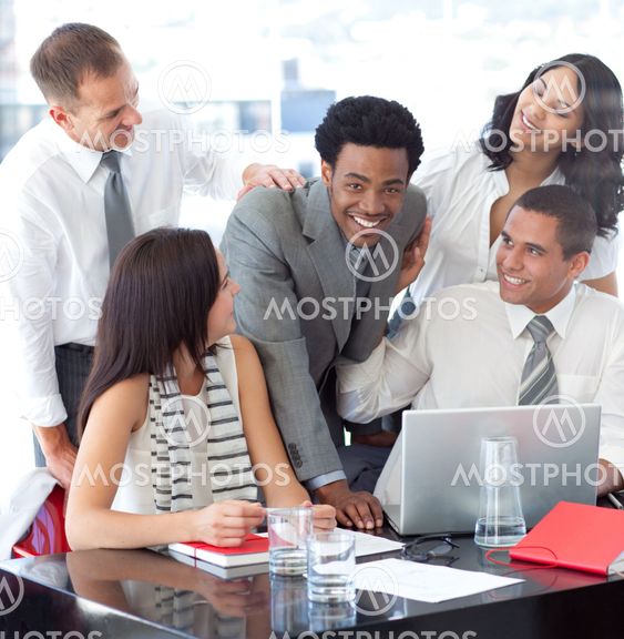 Smiling multi-ethnic business team working with a laptop