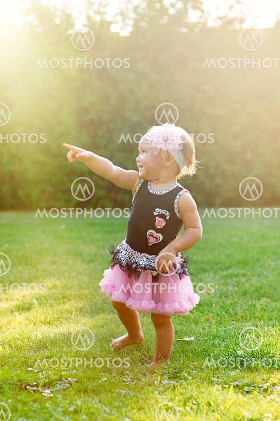 Happy Little girl playing in summer meadow on grass