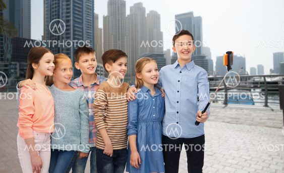 happy children with smartphone and selfie stick