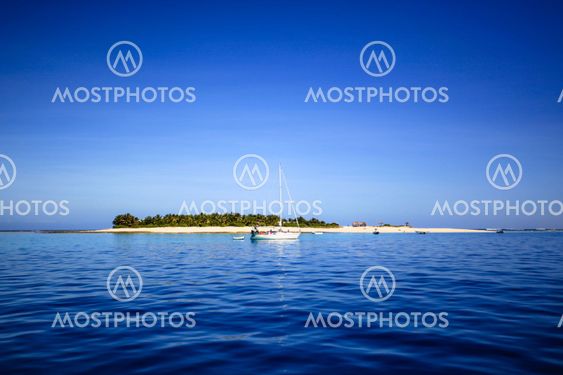 Boat and beautiful Fiji atoll island with white beach