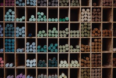 Multicoloured chalk on on the shelf on the store