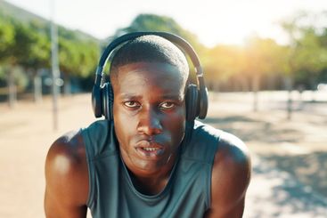 Fitness, break and black man with headphones outdoor for...