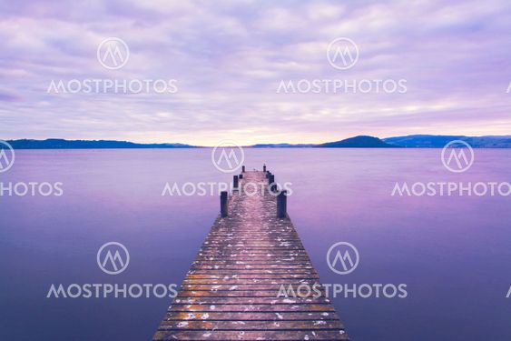 Romantic scene at a pier looking out upon Lake Rotorua at sunrise