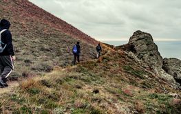 Hikers explore rugged terrain near the coast on an...