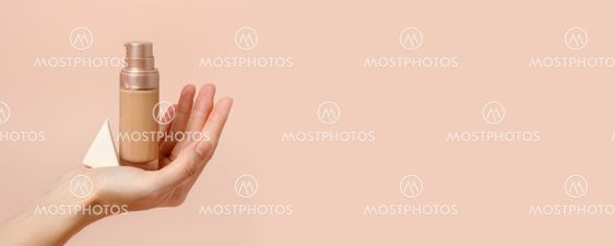 Applying foundation on makeup sponge. Woman's hands with...