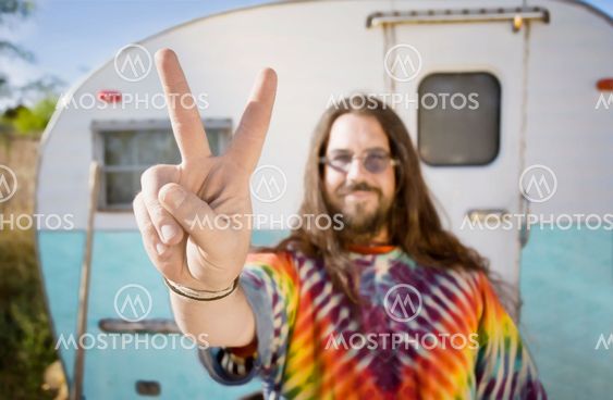 Man in Front of a Trailer Making a Peace Sign