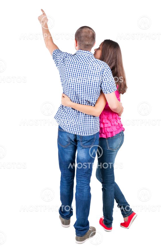 young couple pointing at wal Back view