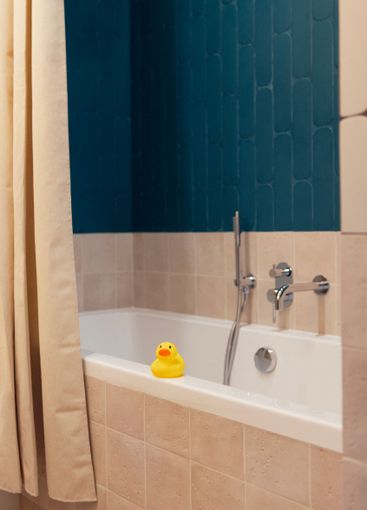 Close-up of a yellow rubber duck on the side of a clean...
