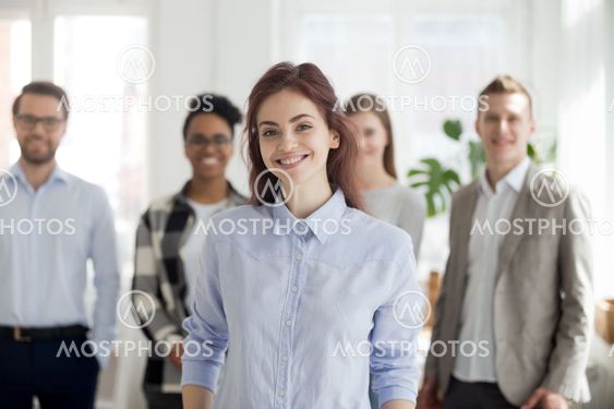 Portrait of smiling female employee foreground posing for pictur
