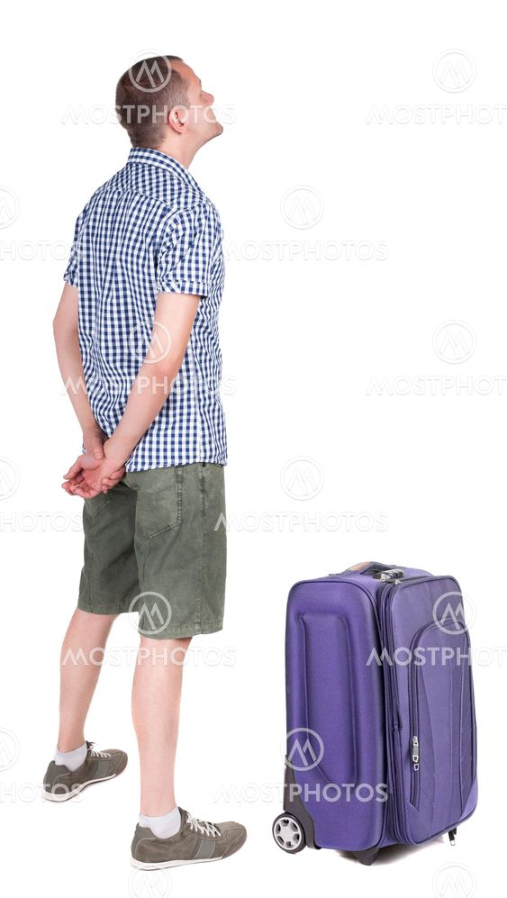 Back view of young man traveling with suitcas.