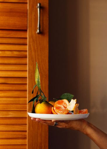 A close-up of a female hand with a ceramic white plate...