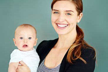 Business woman, baby and happy in studio for motherhood,...