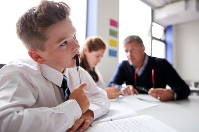 Concentrating Male High School Student Wearing Uniform...