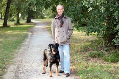 Senior man walking his dog in the woods