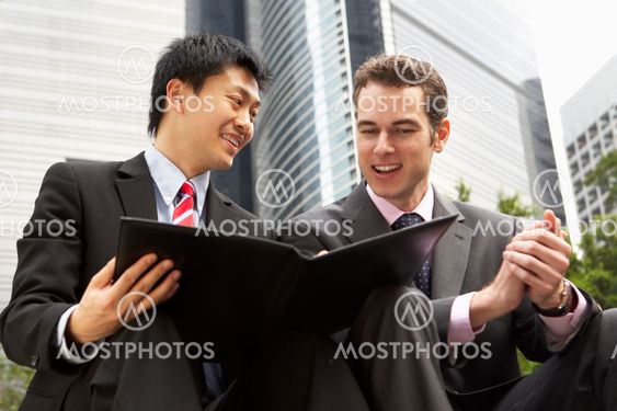 Two Businessmen Discussing Document Outside Office