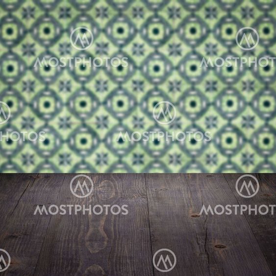 Wood table top and blur vintage ceramic tile pattern wall
