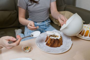 Decorating an Easter cake with white icing.
