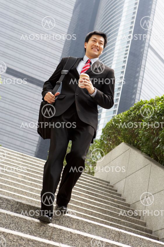 Chinese Businessman Rushing Down Steps Carrying Bag And Takeaway Coffee