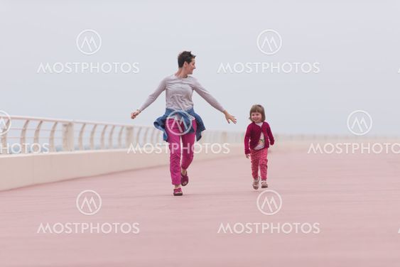 mother and cute little girl on the promenade by the sea
