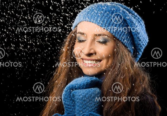 Young happy woman under snowfall