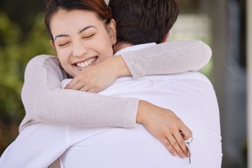 Couple, hug and outdoor with keys for house, joy and...