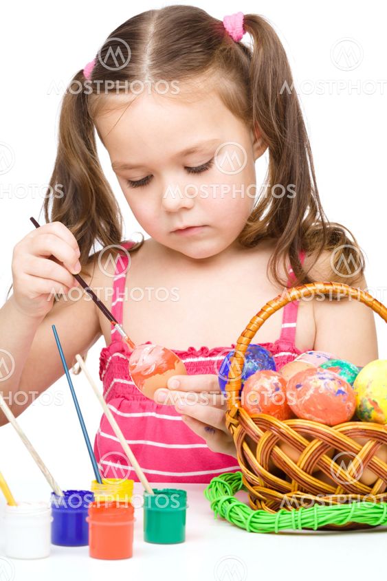 Little girl is painting eggs preparing for Easter