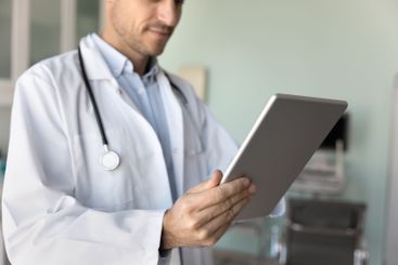 Male physician doctor in white coat using modern technology
