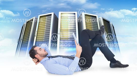 Composite image of businessman lying on floor using tablet